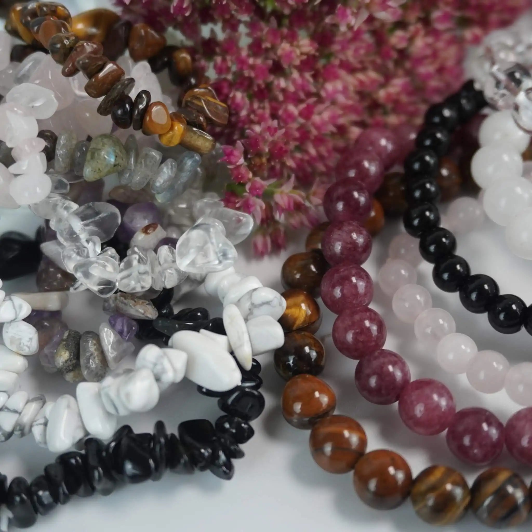 Verschiedene Edelsteinarmbänder aus Rosenquarz, Tigerauge, Onyx und Bergkristall