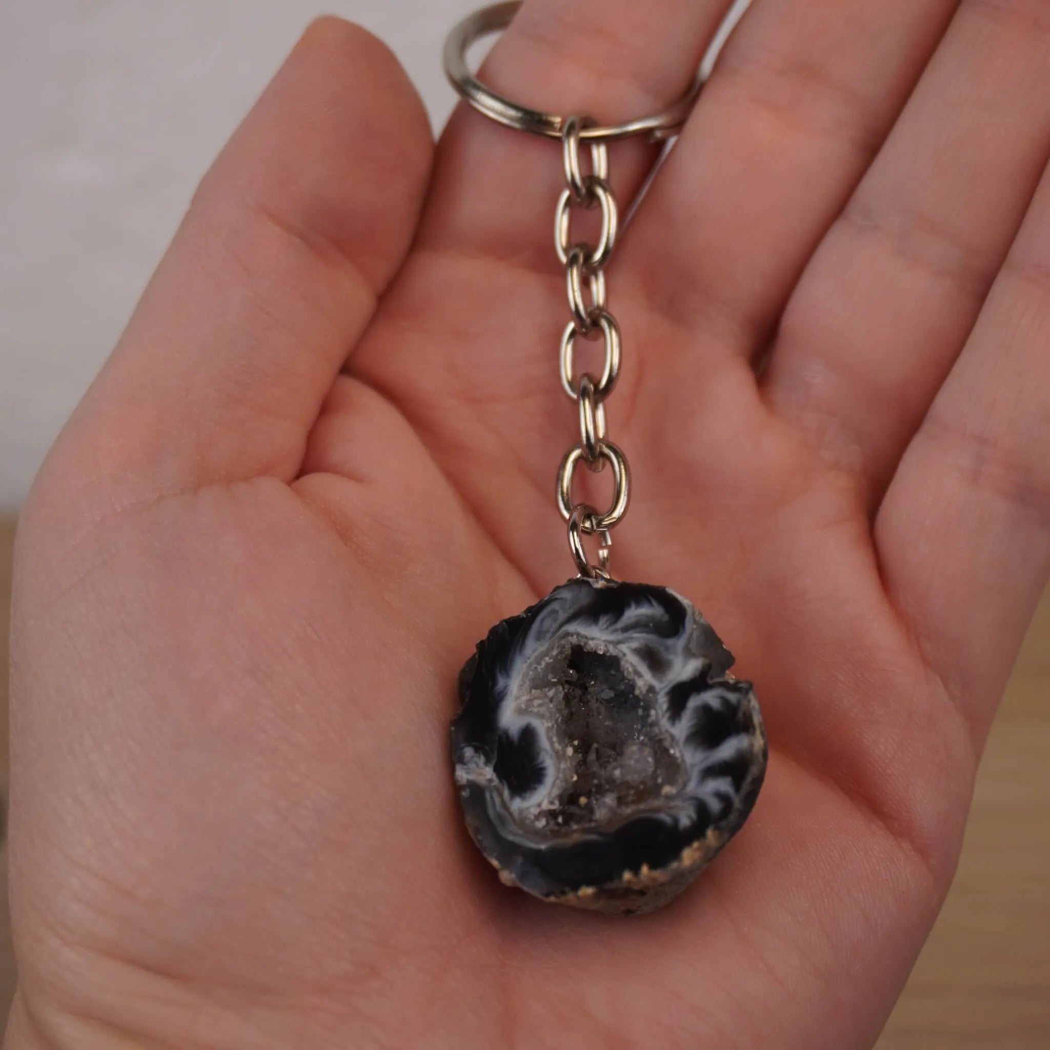 Geöffnete Achat Geode Schlüsselanhänger in einer Hand gehalten