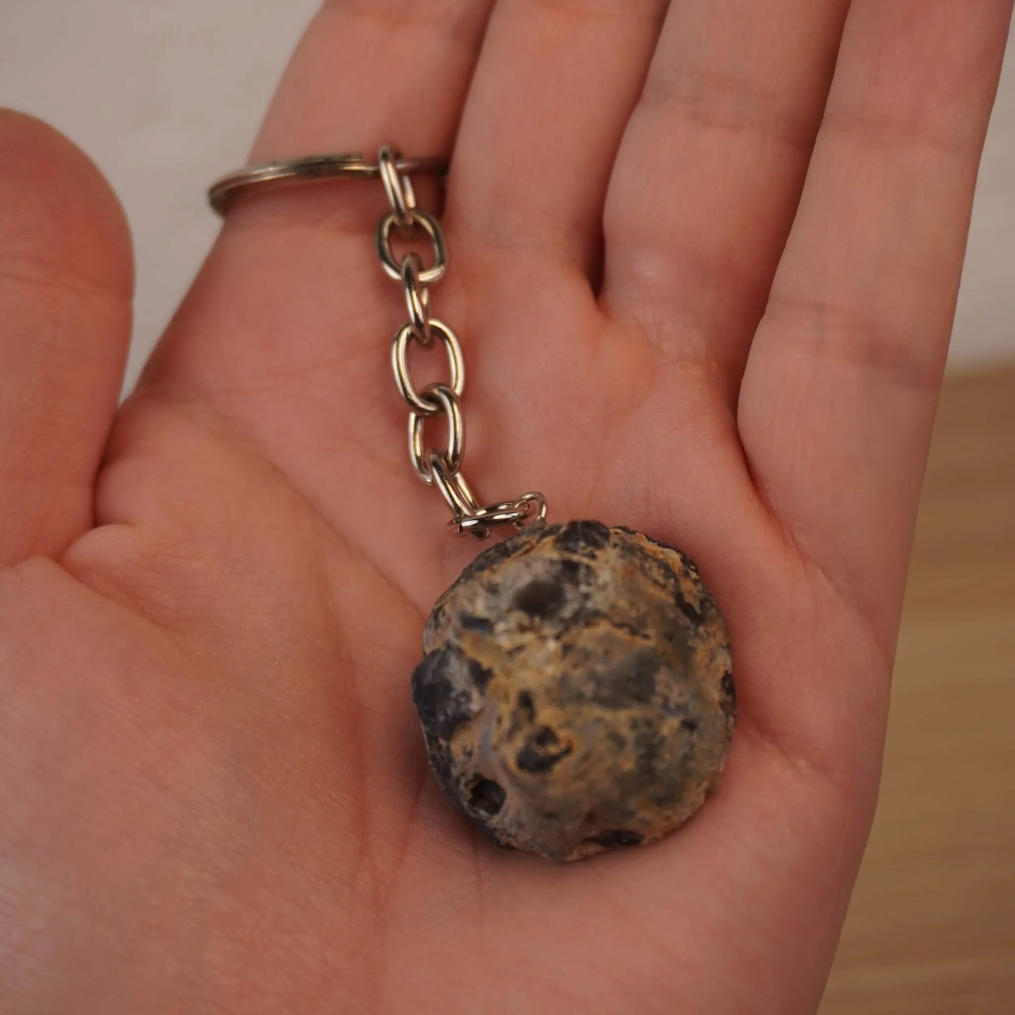 Rückseite Achat Geode Schlüsselanhänger mit naturbelassenem Stein in einer geöffneten Hand