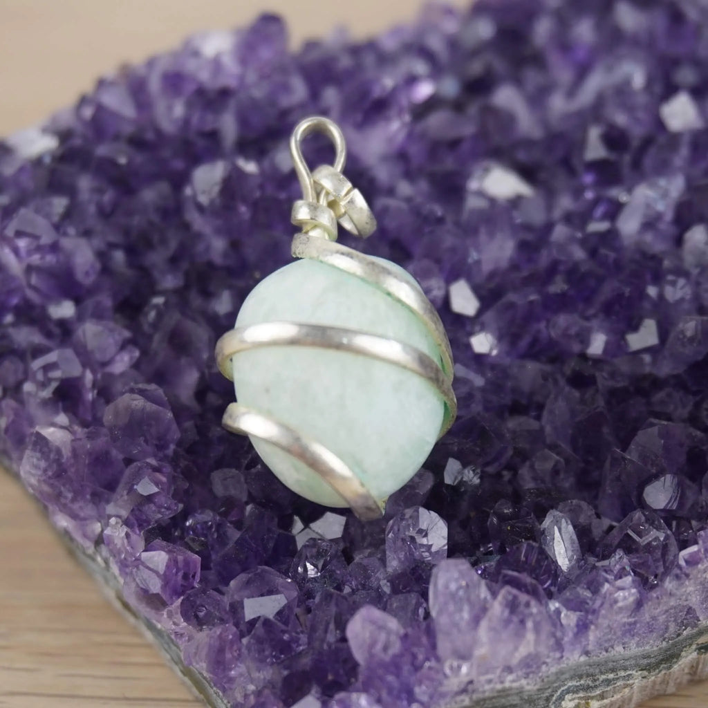 Amazonit Kettenanhänger mit Silberfassung präsentiert auf violetter Amethyst-Druse
