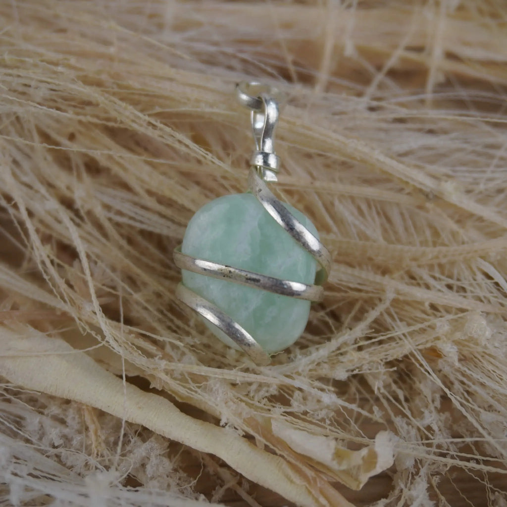 Amazonit Kettenanhänger mit Silberfassung dekoriert auf hellen Naturfasern