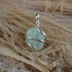 Amazonit Kettenanhänger mit Silberfassung dekoriert auf hellen Naturfasern