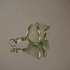 Amazonit Kettenanhänger mit silberfarbener Spiralfassung und Spiegelung auf glatter Fläche