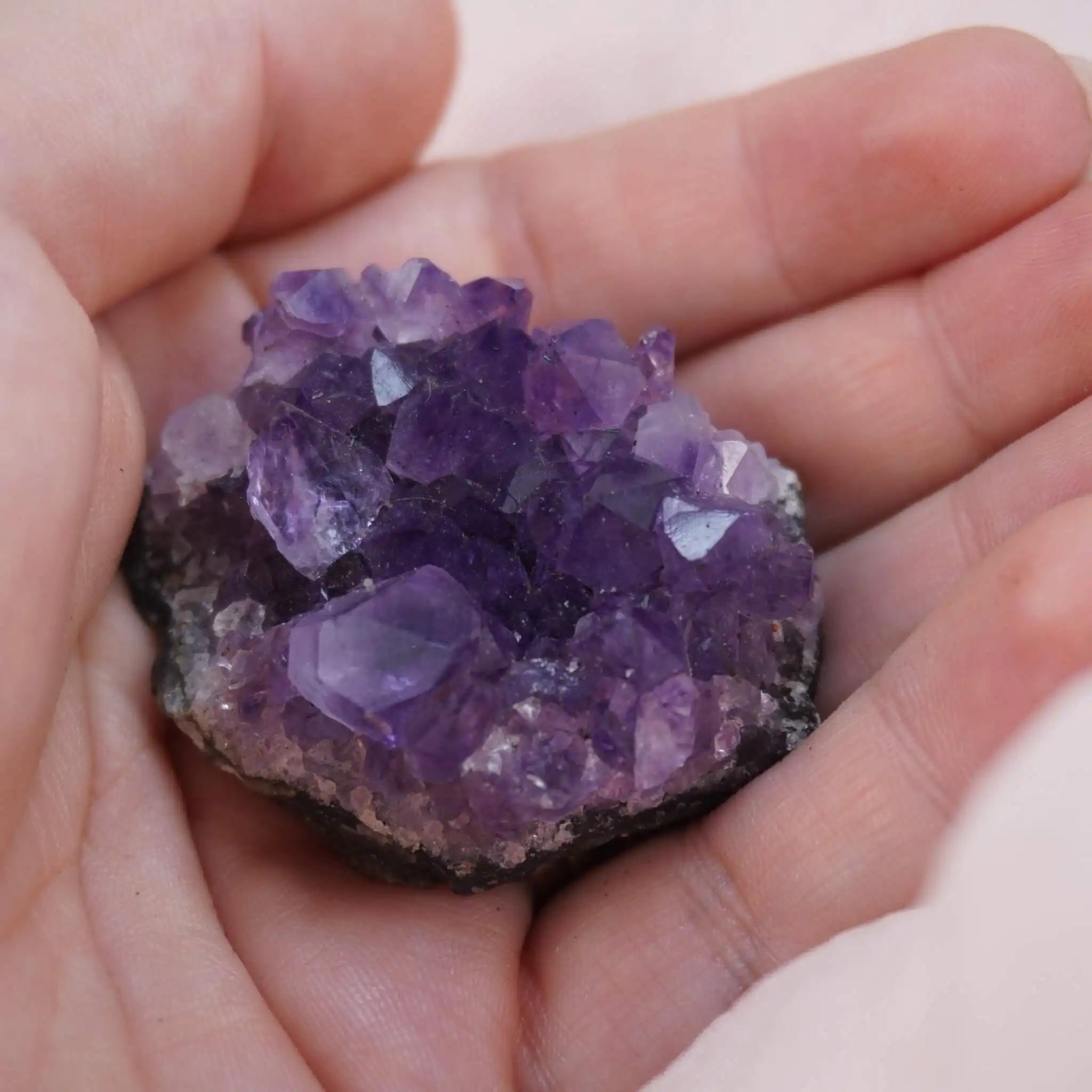 Amethystdruse in einer Hand gehalten