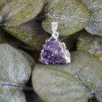 Amethyst Druse Kettenanhänger mit Silberfassung auf grünen Eukalyptusblättern präsentiert