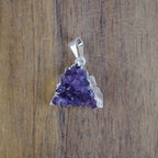 Amethyst Druse Kettenanhänger mit Silberfassung vor Holzuntergrund