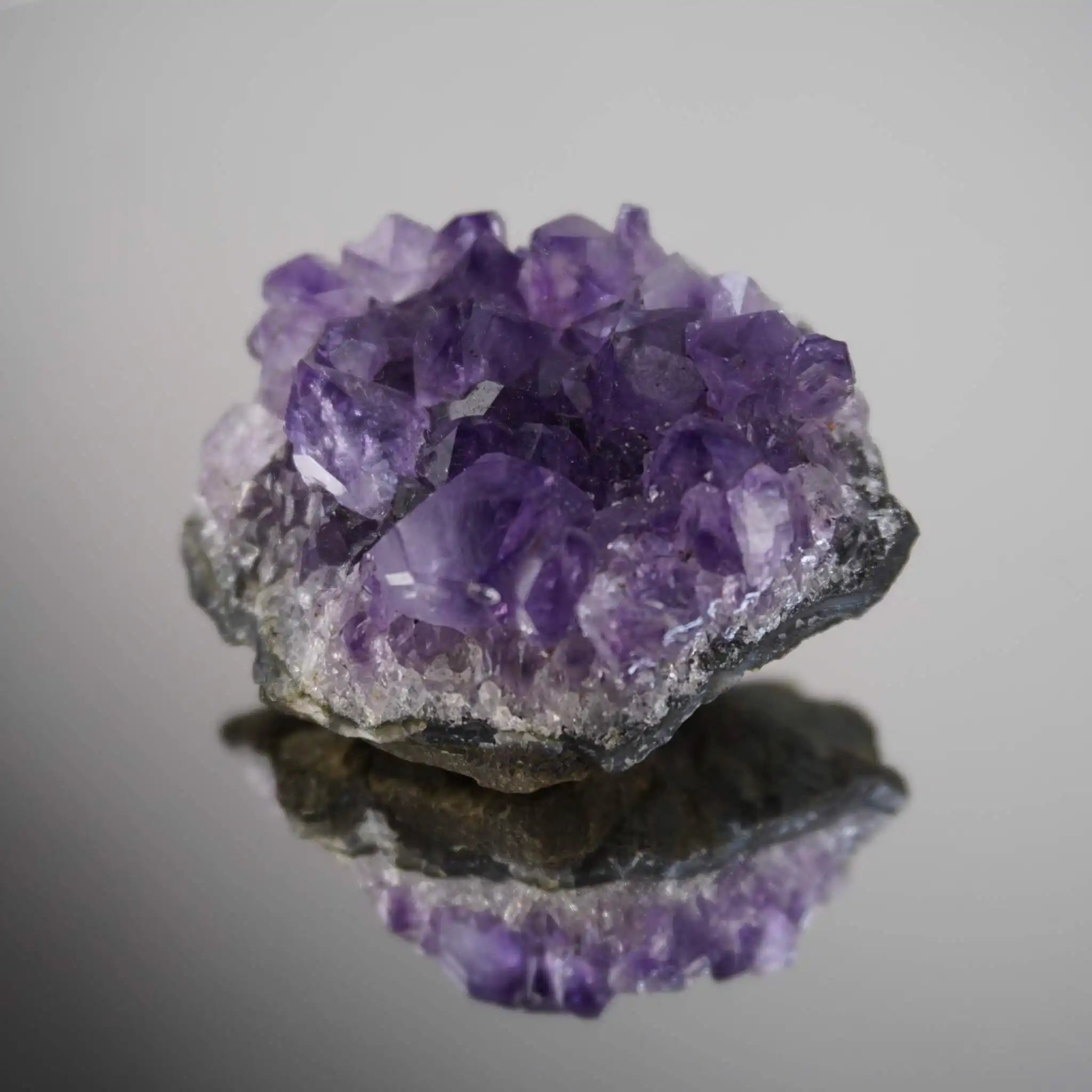 Amethystdruse mit Spiegelung auf glänzender Fläche