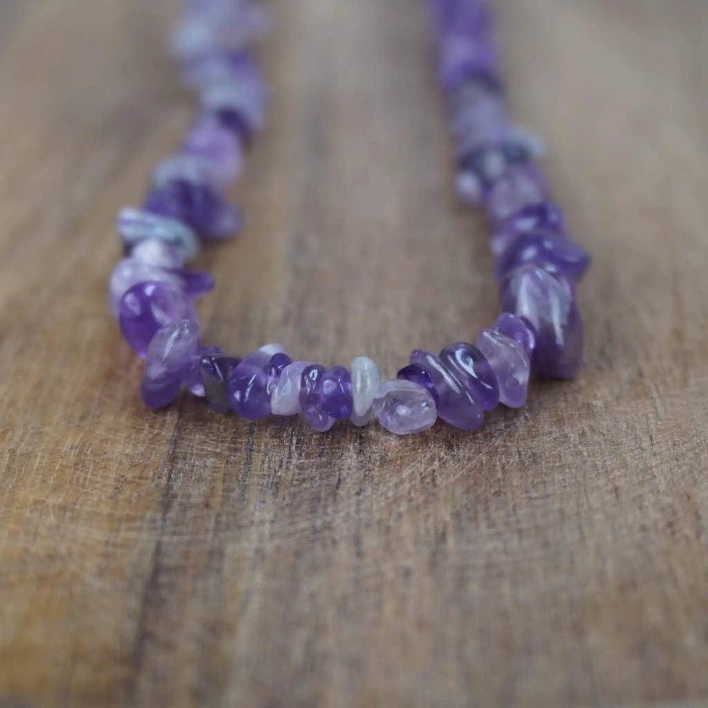 Amethyst Halskette mit Splittersteinen auf rustikaler Holzoberfläche in Nahaufnahme