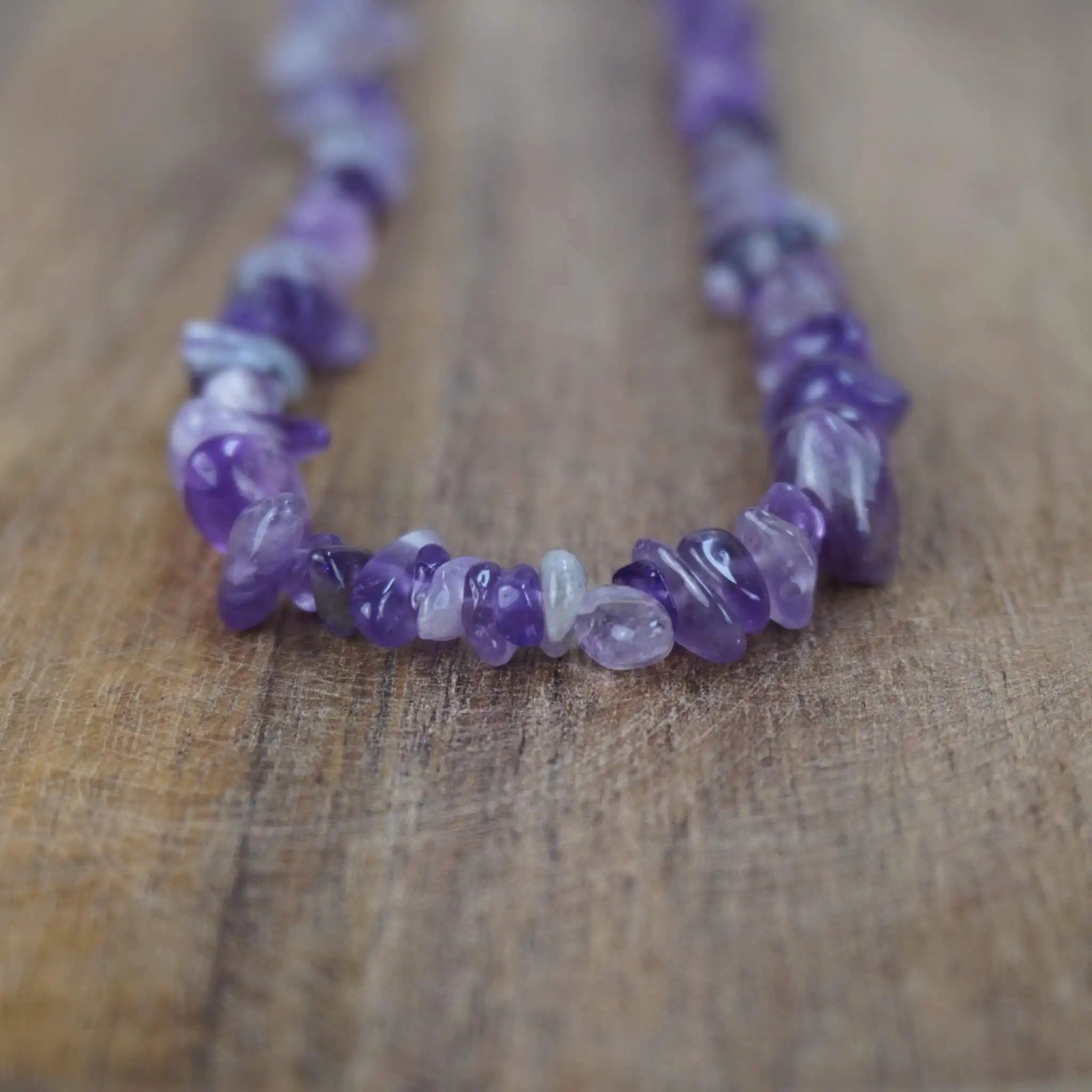 Amethyst Halskette mit Splittersteinen auf rustikaler Holzoberfläche in Nahaufnahme