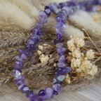 Amethyst Halskette mit Splittersteinen auf naturfarbenen Trockenblumen und Getreide dekoriert