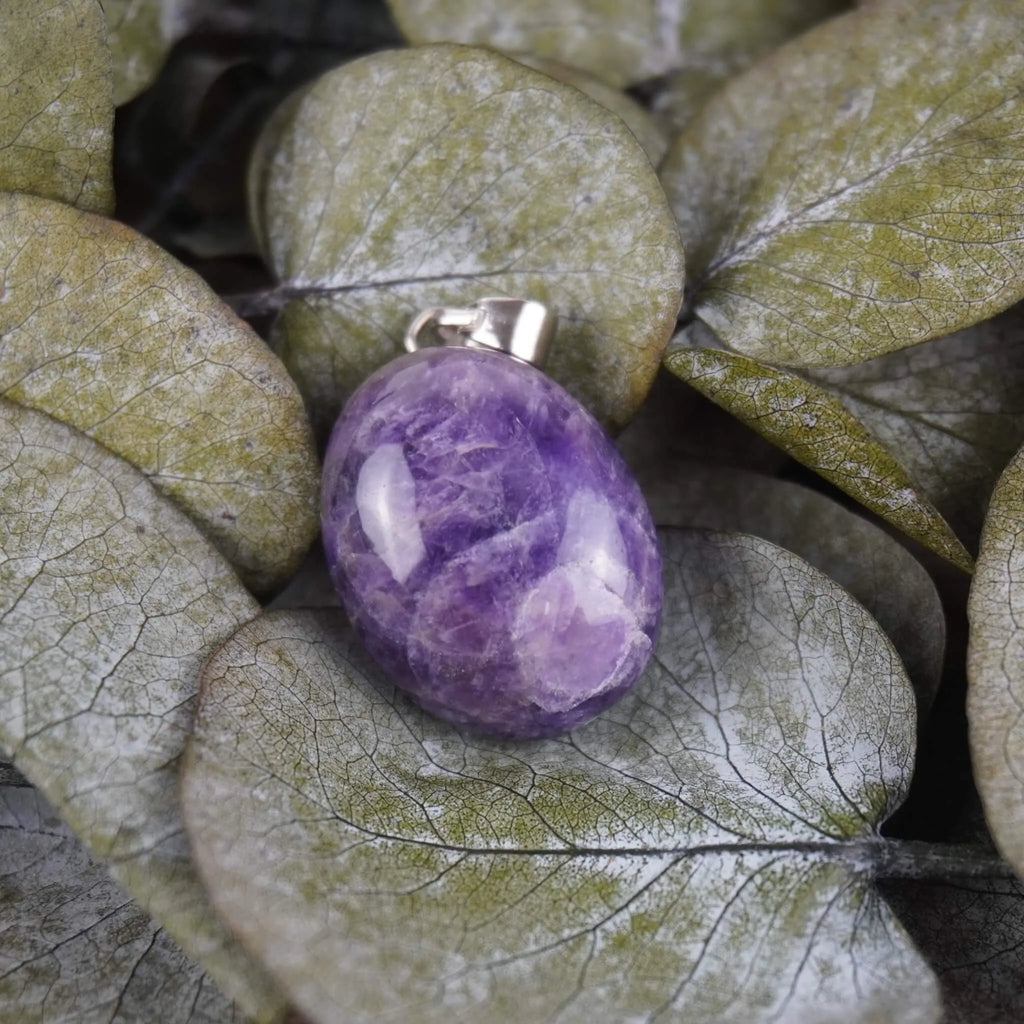 Amethyst Trommelstein Kettenanhänger mit Silber Öse auf grünen Eukalyptusblättern dekoriert