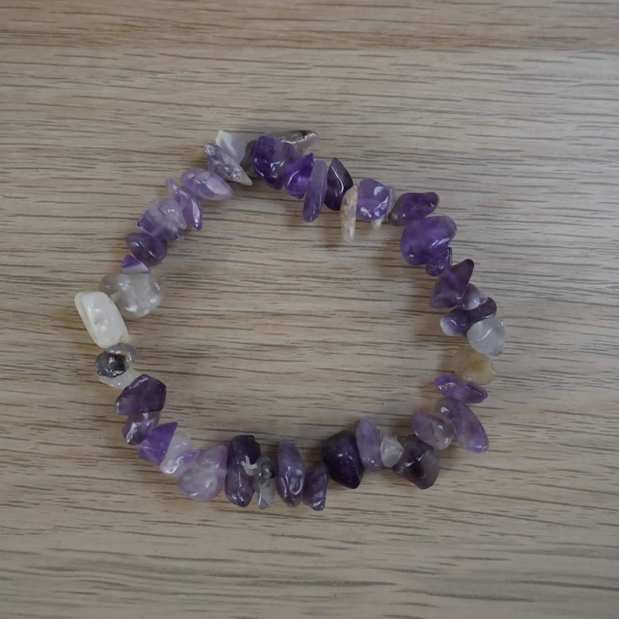 Amethyst Splitterarmband mit violetten Natursteinen auf heller Holzoberfläche präsentiert