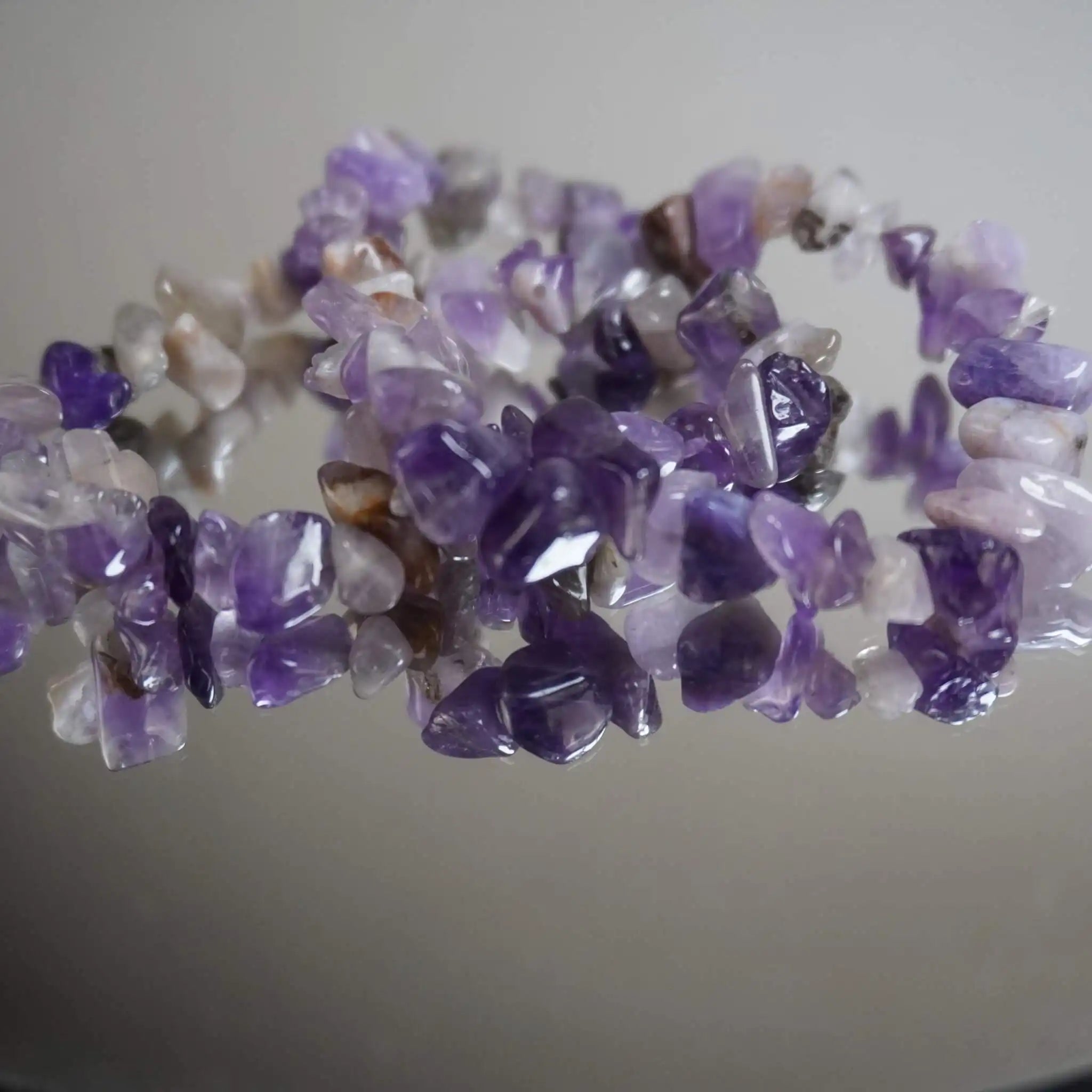 Nahaufnahme eines Amethyst Splitterarmbands auf spiegelnder Fläche