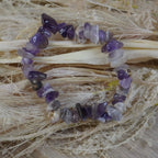 Lila Amethyst Splitterarmband auf hellem Trockenblumen fotografiert