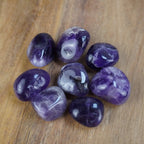 Amethyst Trommelsteine auf einer Holzoberfläche