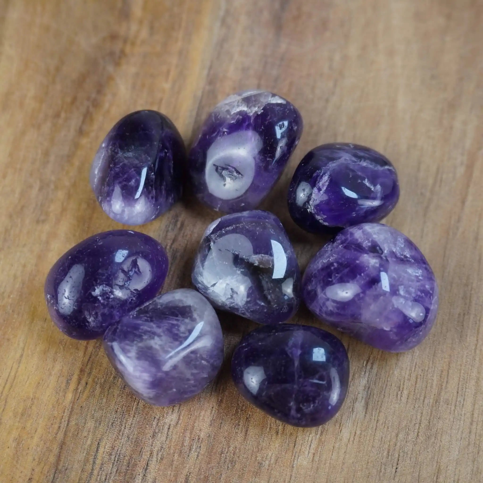Amethyst Trommelsteine auf einer Holzoberfläche