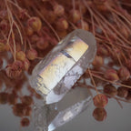 Angel Aura Bergkristall Spitze vor rosafarbenen Trockenblumen dekorativ arrangiert