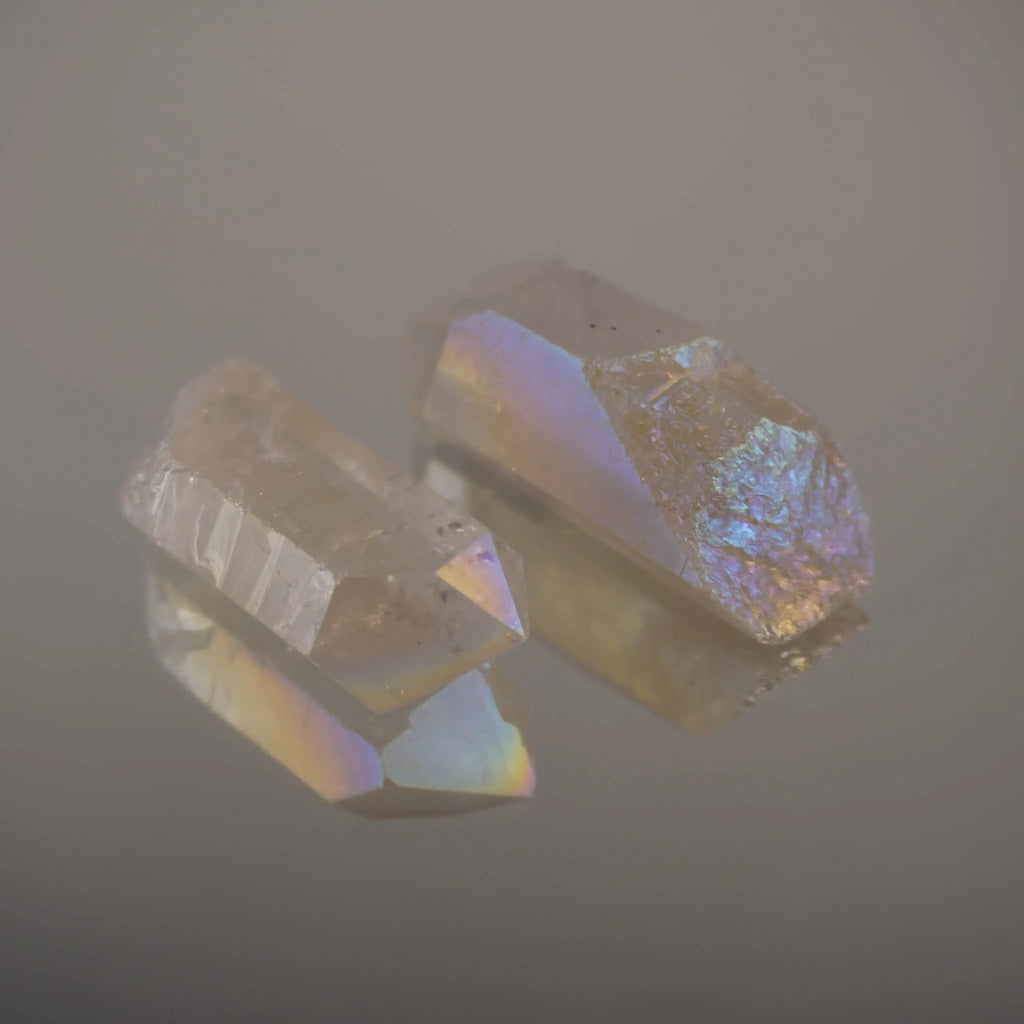 Zwei Angel Aura Bergkristall Spitzen mit Spiegelung auf glänzender Fläche