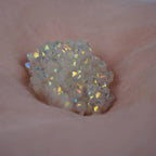 Angel Aura Cluster Kristall mit Regenbogenschimmer auf rosafarbenem Stoff