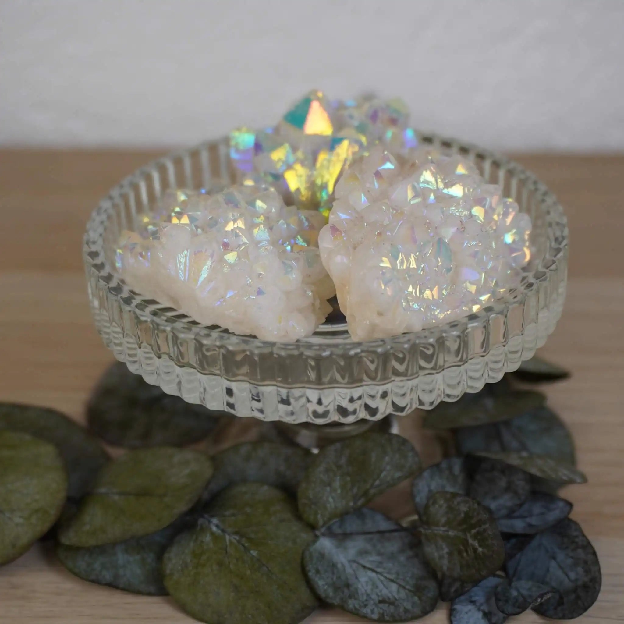 Mehrere Angel Aura Cluster Kristalle mit intensivem Schimmer auf Glasständer dekoriert