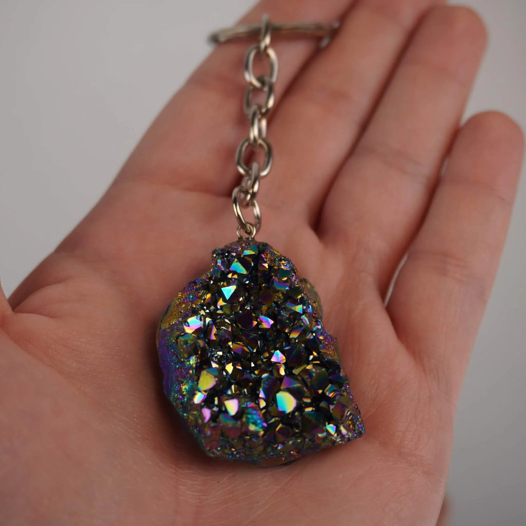 Titan Aqua Aura Druse Schlüsselanhänger mit Metallkette in einer Hand gehalten