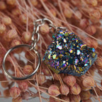 Aqua Aura Druse Schlüsselanhänger mit funkelnder Oberfläche arrangiert auf rosa Trockenblumen