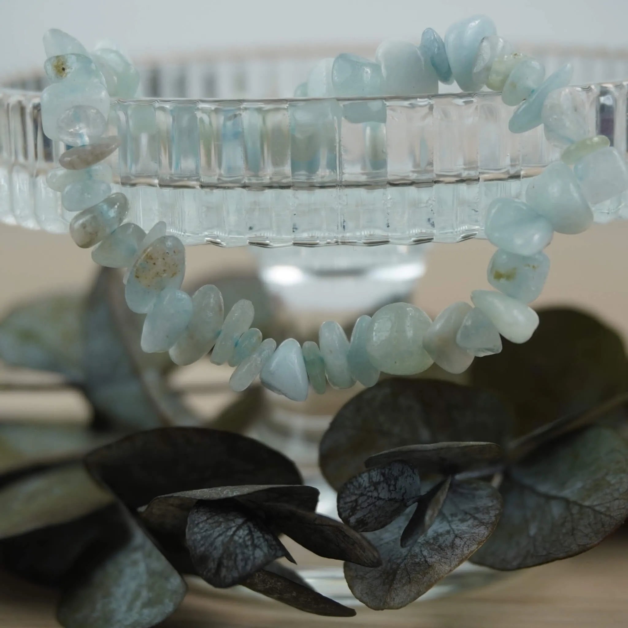 Aquamarin‑Splitterarmband dekorativ auf Glas‑Schale mit Eukalyptus