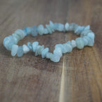 Aquamarin‑Splitterarmband liegt auf rustikaler Holzoberfläche