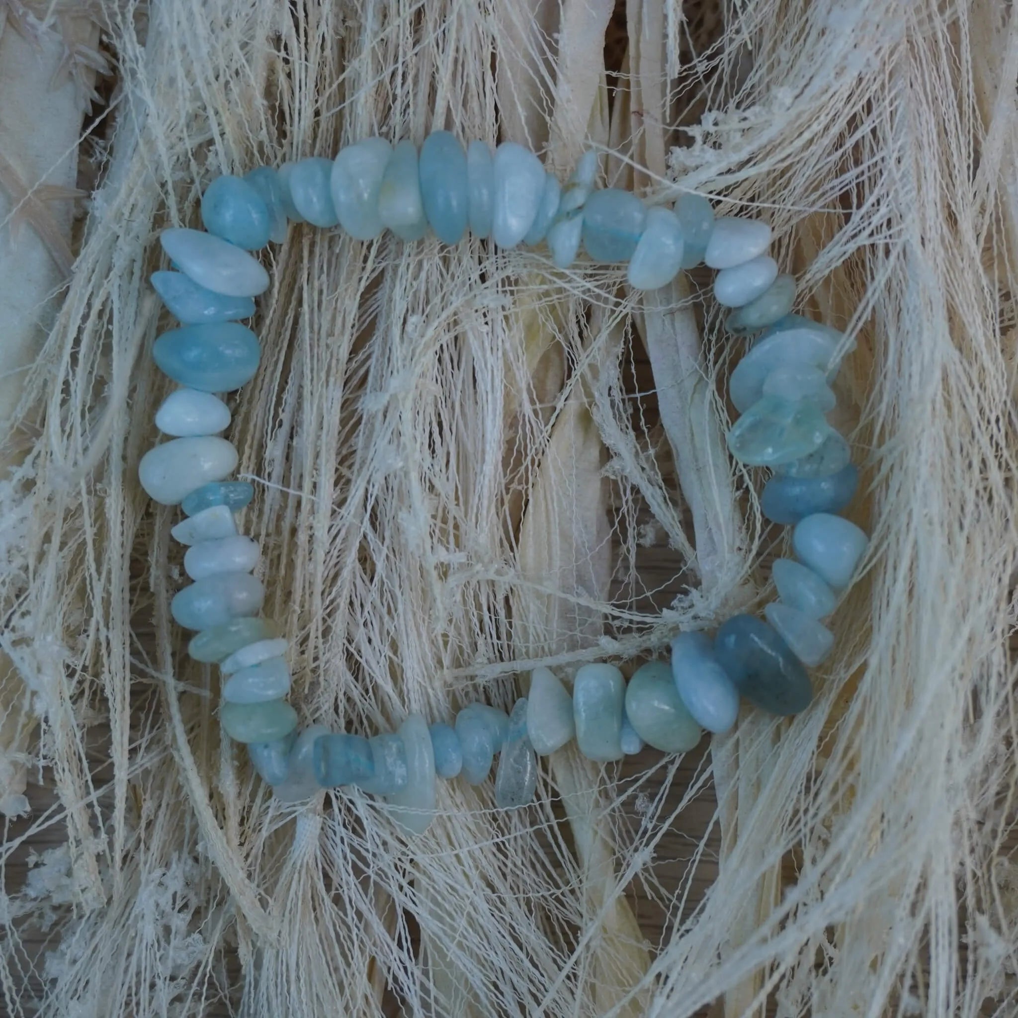 Aquamarin‑Splitterarmband auf hellem Naturfaserdekor