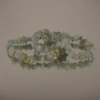 Aquamarin‑Splitterarmband auf spiegelnder, heller Fläche dekoriert