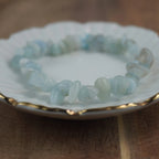 Aquamarin‑Splitterarmband auf weißem Teller mit Goldrand