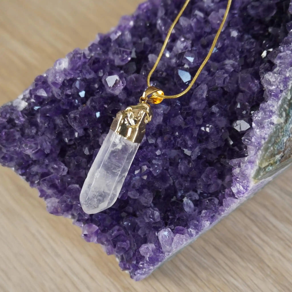 18k vergoldete Halskette mit Bergkristall-Anhänger auf violettem Amethyst-Deko Stein