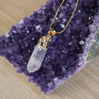 18k vergoldete Halskette mit Bergkristall-Anhänger auf violettem Amethyst-Deko Stein