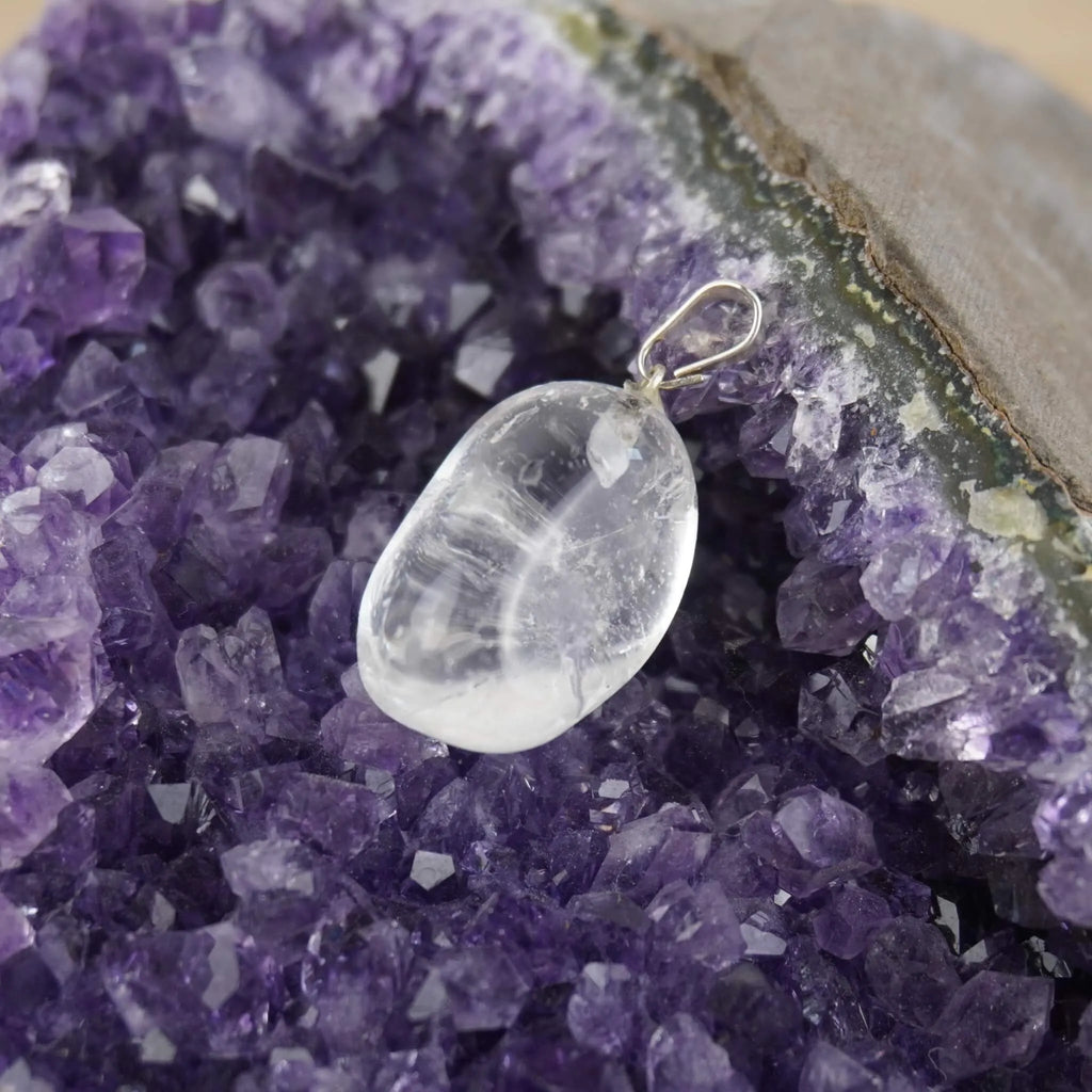 Klarer Bergkristall Trommelstein Kettenanhänger präsentiert auf Amethyst-Druse
