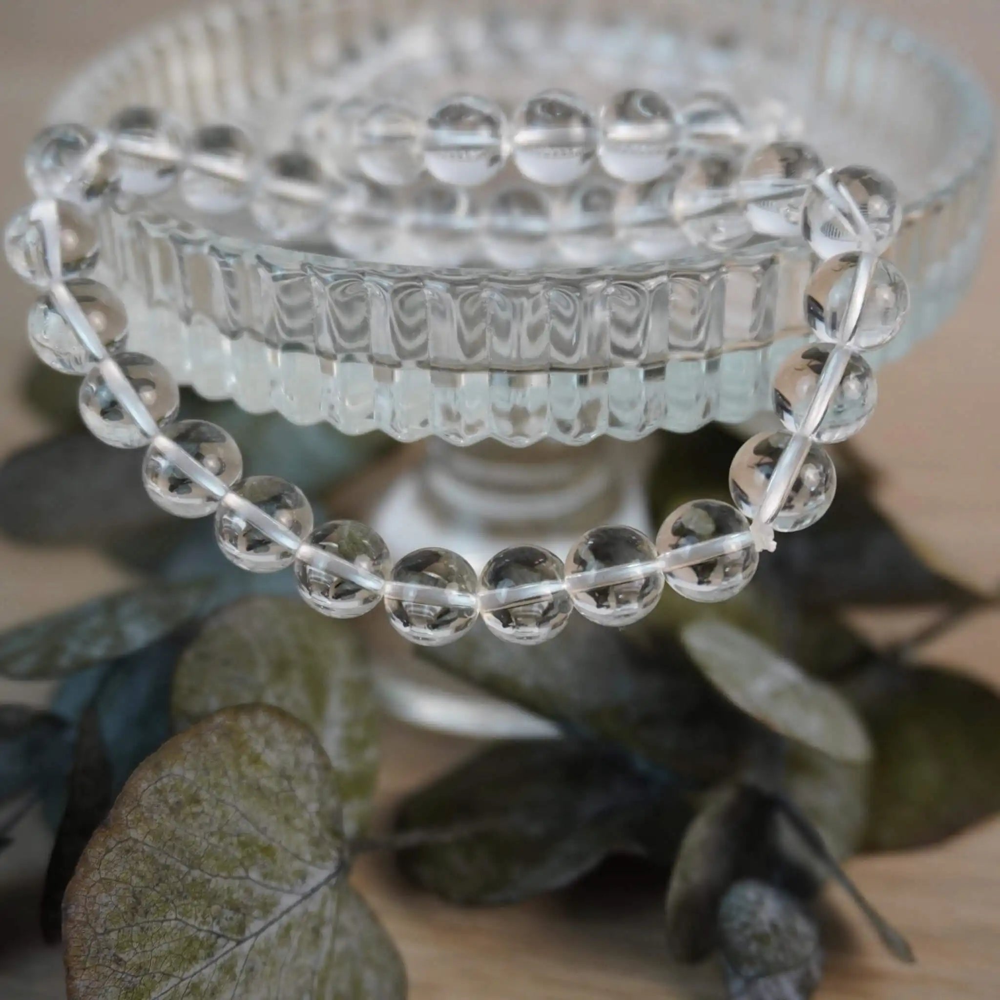 Bergkristall Kugelarmband auf Kristallschale mit Blättern