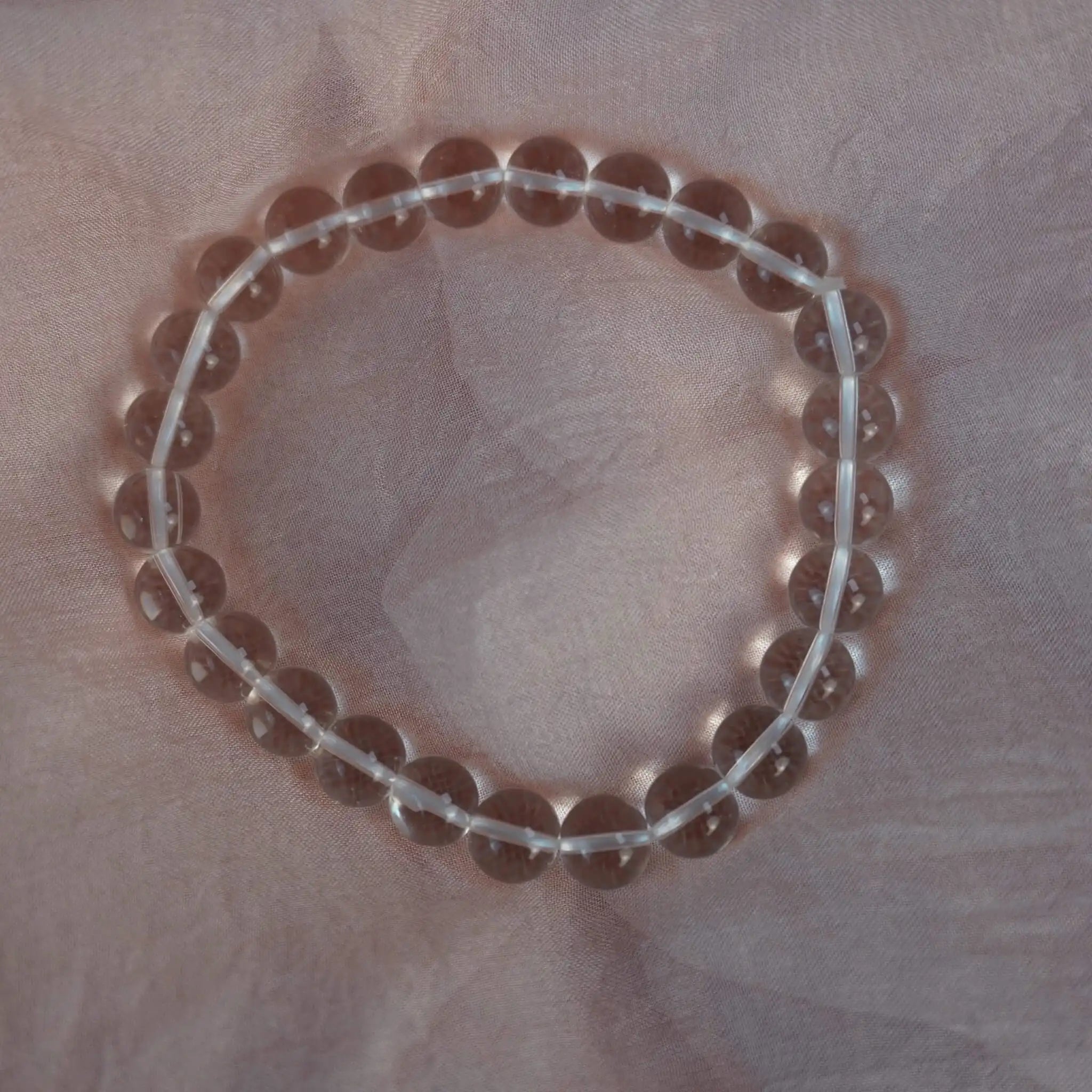 Bergkristall Kugelarmband auf rosafarbenem Stoff