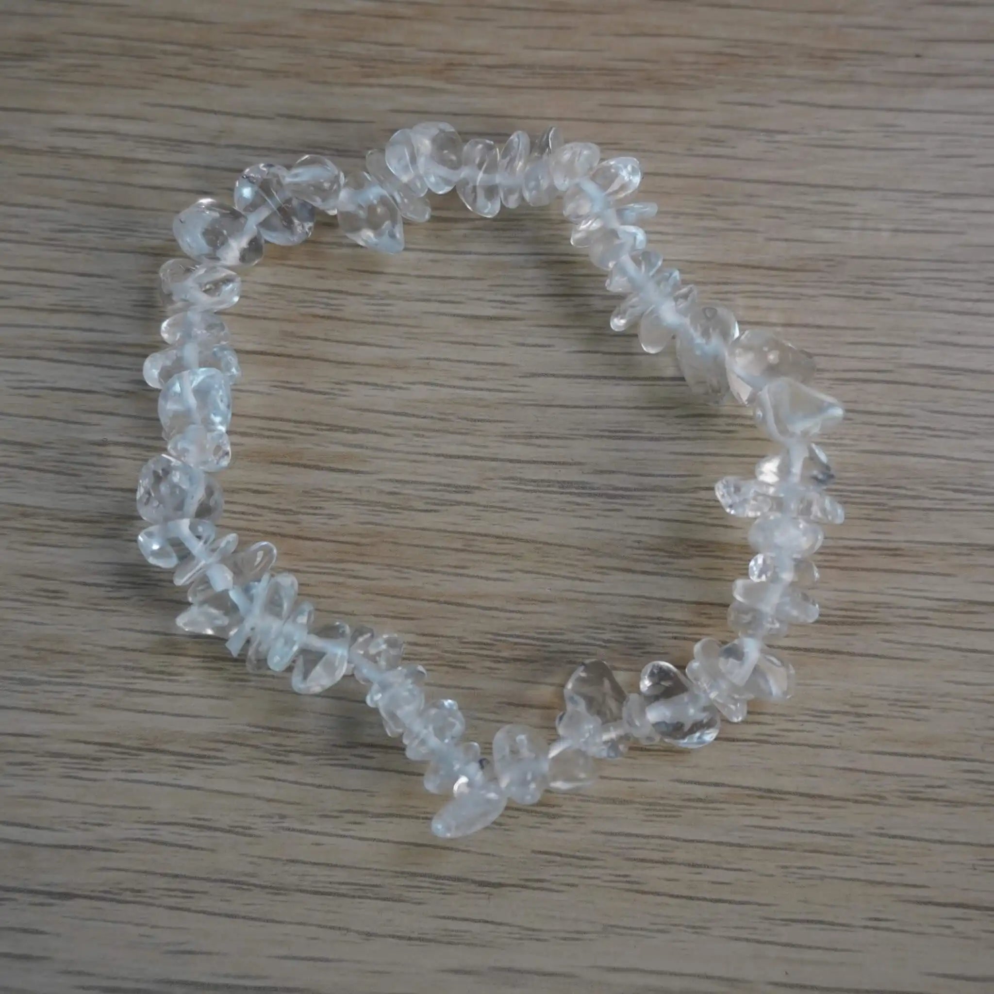 Bergkristall Splitterarmband aus klaren Natursteinen auf heller Holzoberfläche
