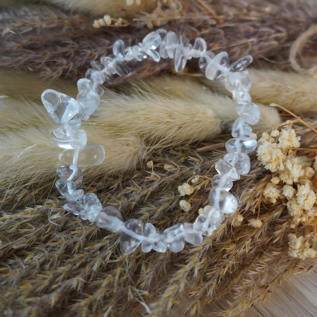 Bergkristall Splitterarmband mit klaren Steinen auf naturfarbenen Trockenpflanzen dekoriert