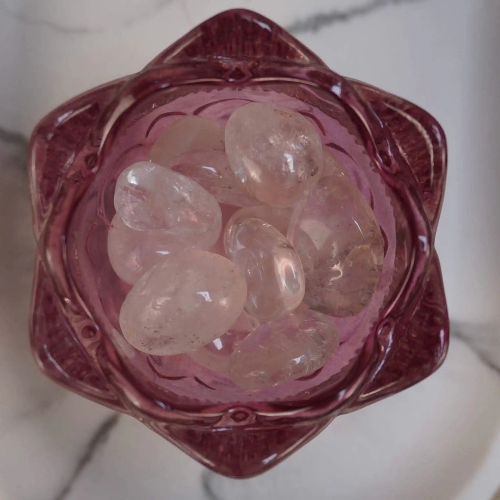 Mehrere Bergkristall Trommelsteine in einer rosa Glasschale