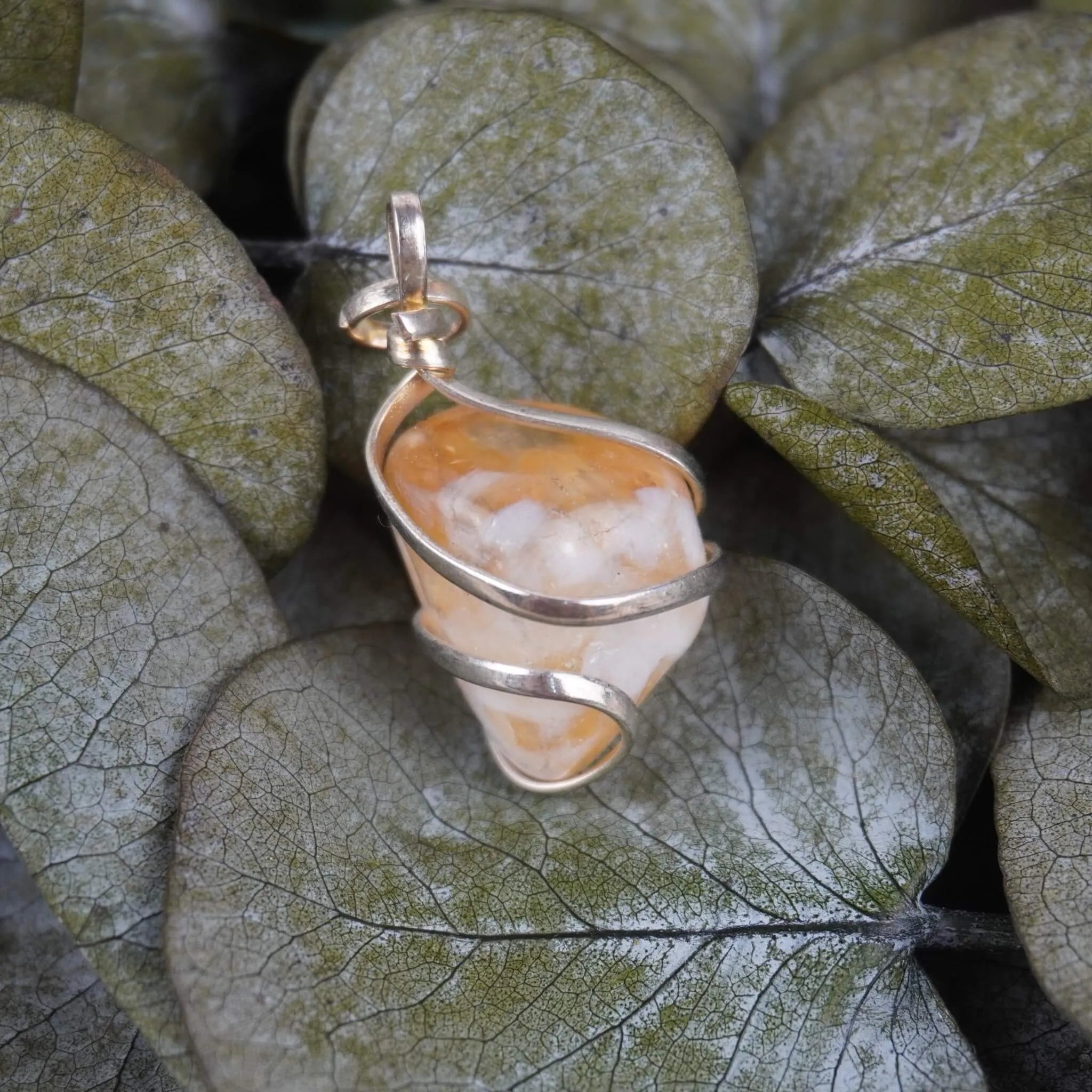 Citrin Kettenanhänger mit silberfarbener Fassung auf Eukalyptusblättern