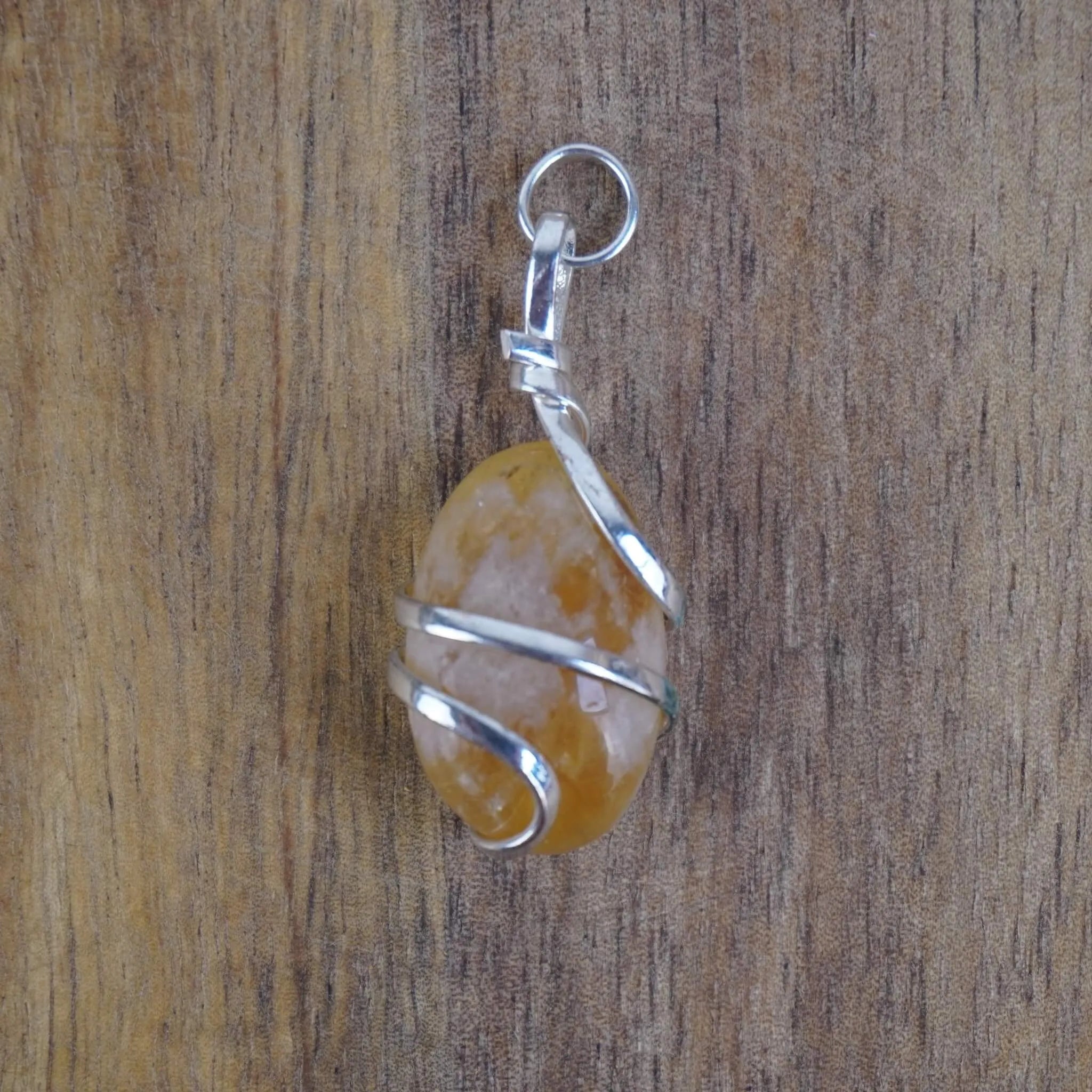 Citrin Kettenanhänger mit Silberfassung vor Holzuntergrund
