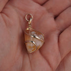 Citrin Kettenanhänger mit silberfarbener Spiralfassung in einer Hand liegend