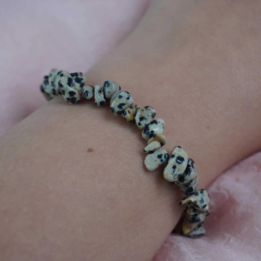 Dalmatiner Jaspis Splitterarmband am Handgelenk auf rosa Untergrund