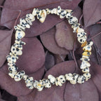 Dalmatiner Jaspis Splitterarmband auf violett-braunen Blättern dekoriert