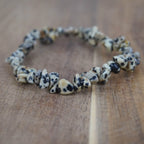 Dalmatiner Jaspis Splitterarmband auf warmer Holzoberfläche, natürlich wirkend