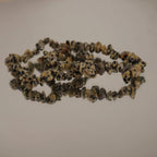 Dalmatiner Jaspis Splitterarmband auf spiegelnder Fläche mit sanfter Reflexion