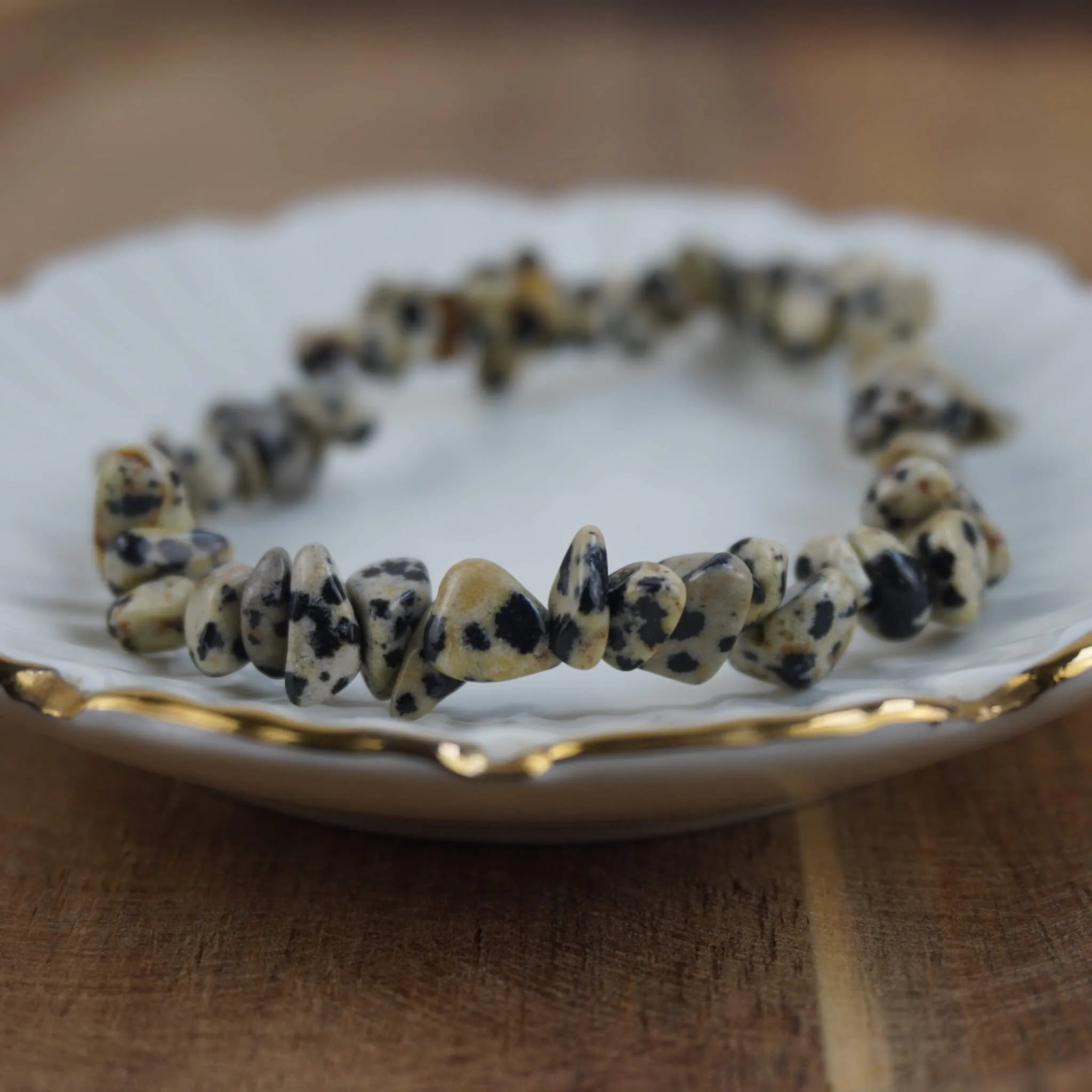 Dalmatiner Jaspis Splitterarmband auf weißem Teller mit Goldrand präsentiert