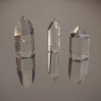 Drei stehende klare Bergkristall Spitzen mit deutlicher Spiegelung auf Glasfläche