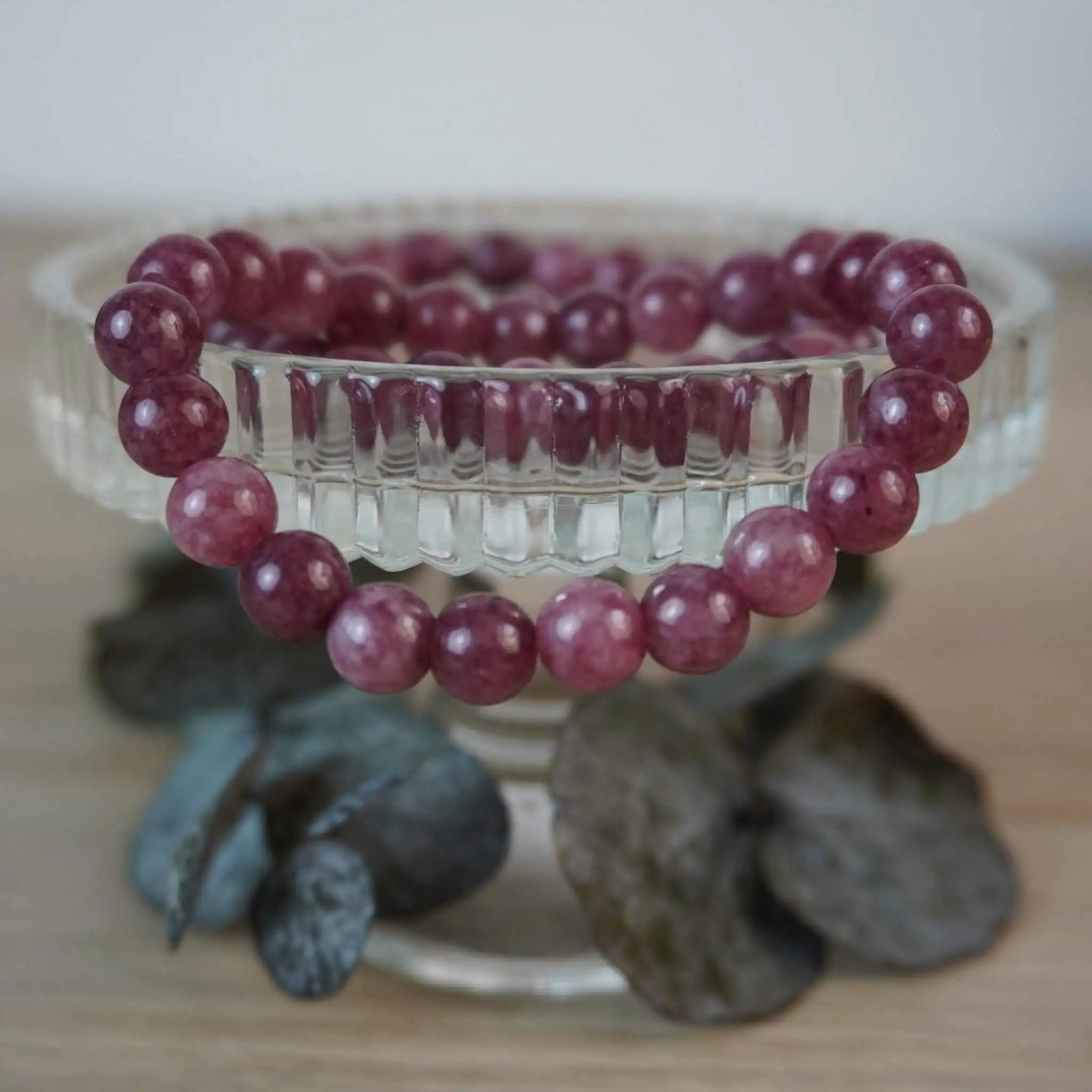Erdbeerquarz Kugelarmband auf edlem Glasdisplay präsentiert