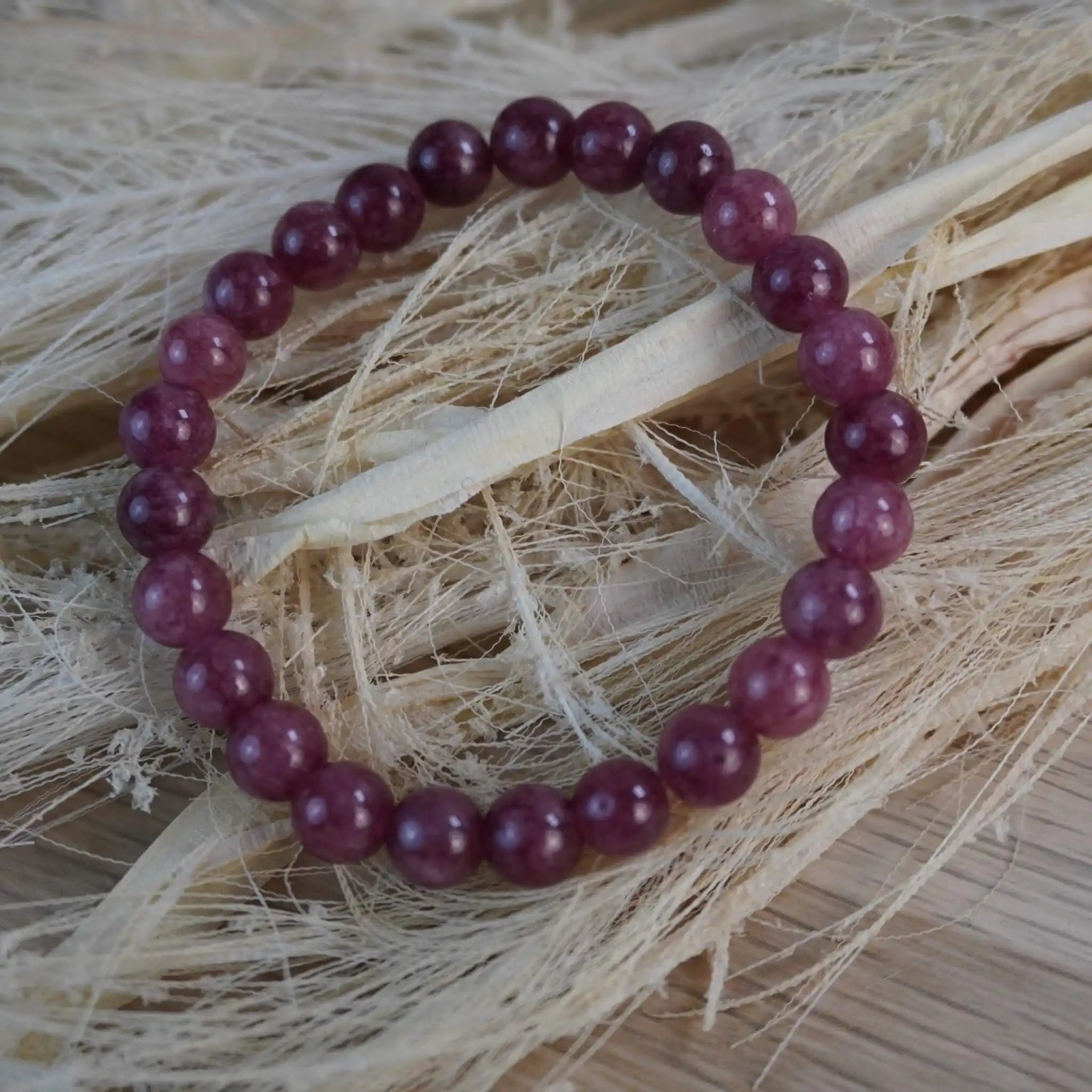 Erdbeerquarz Kugelarmband auf heller Naturdekoration